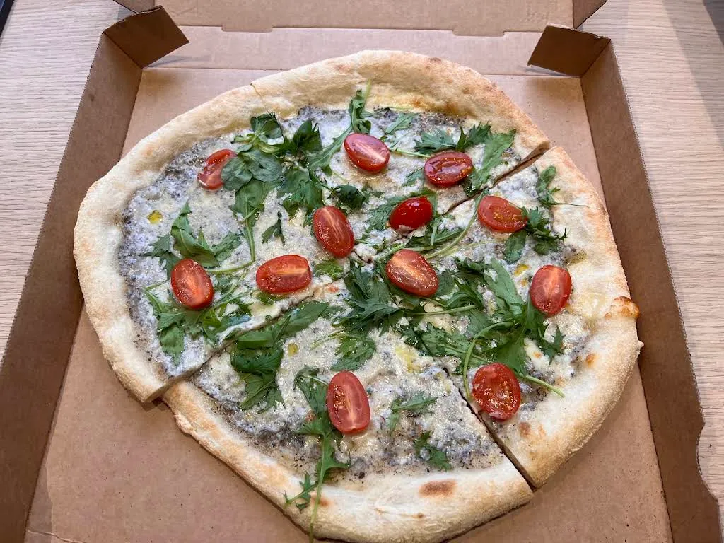 Pizza base crème de truffe, roquette et tomates cerises